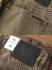 製品画像:アメカジ風泥染めストレートデニムパンツの正面展示。低彩度のブラウンカラーがヴィンテージ感を演出。
詳細画像:カスタムボタンとウォッシュ加工のディテールをクローズアップ。レザーパッチがデザインのアクセントに。