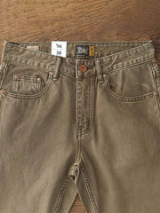 製品画像:アメカジ風泥染めストレートデニムパンツの正面展示。低彩度のブラウンカラーがヴィンテージ感を演出。
詳細画像:カスタムボタンとウォッシュ加工のディテールをクローズアップ。レザーパッチがデザインのアクセントに。