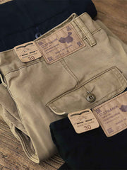 製品画像:アメリカンクラシックストレートツイルパンツの正面図。クラシックなワークスタイルとカジュアル感が共存し、三季節に適した全コットン素材のアイテム。
詳細画像:後ろポケットに施されたフラップデザインのディテールを強調したクローズアップ画像。ワークテイストと実用性を兼ね備えたスタイル。