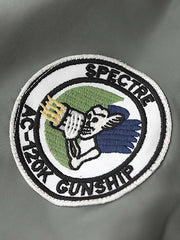 製品画像:ヴィンテージMA-1フライトジャケットの正面図。防水ナイロン素材とオレンジ色の裏地、刺繍バッジが特徴的なデザイン。
詳細画像:刺繍バッジと識別テープ、ジッパーのディテールをクローズアップした画像。ミリタリーウェアの本格的なスタイルを強調。