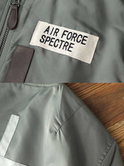 製品画像:ヴィンテージMA-1フライトジャケットの正面図。防水ナイロン素材とオレンジ色の裏地、刺繍バッジが特徴的なデザイン。
詳細画像:刺繍バッジと識別テープ、ジッパーのディテールをクローズアップした画像。ミリタリーウェアの本格的なスタイルを強調。