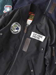 製品画像:ヴィンテージMA-1フライトジャケットの正面図。防水ナイロン素材とオレンジ色の裏地、刺繍バッジが特徴的なデザイン。
詳細画像:刺繍バッジと識別テープ、ジッパーのディテールをクローズアップした画像。ミリタリーウェアの本格的なスタイルを強調。