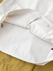 製品画像: 軽量 Cordura ナイロン 速乾トップ 正面、耐摩耗性・リップストップ機能
詳細画像: 両サイドの大容量ポケットと伸縮性のある袖口のディテール、オーバーサイズシルエット