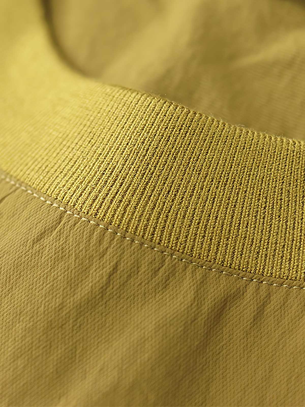 製品画像: 軽量 Cordura ナイロン 速乾トップ 正面、耐摩耗性・リップストップ機能
詳細画像: 両サイドの大容量ポケットと伸縮性のある袖口のディテール、オーバーサイズシルエット