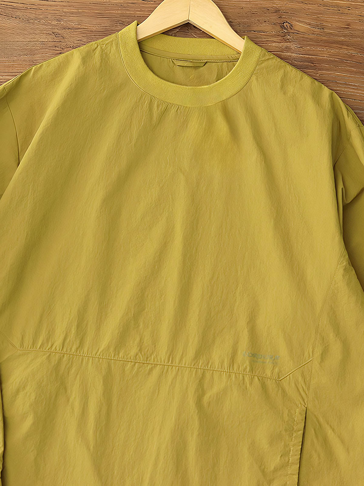 製品画像: 軽量 Cordura ナイロン 速乾トップ 正面、耐摩耗性・リップストップ機能
詳細画像: 両サイドの大容量ポケットと伸縮性のある袖口のディテール、オーバーサイズシルエット