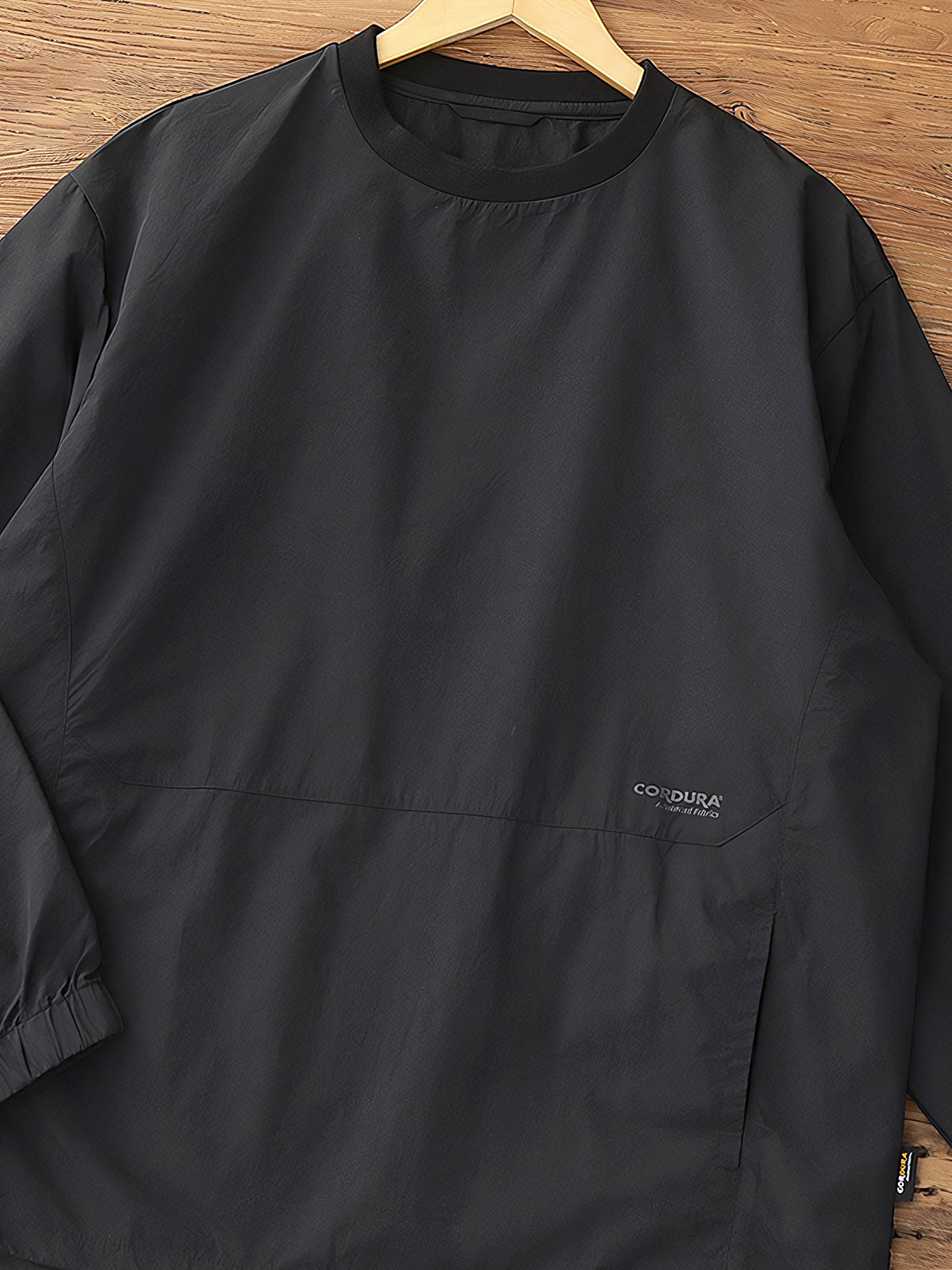 製品画像: 軽量 Cordura ナイロン 速乾トップ 正面、耐摩耗性・リップストップ機能
詳細画像: 両サイドの大容量ポケットと伸縮性のある袖口のディテール、オーバーサイズシルエット