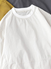 製品画像: 軽量 Cordura ナイロン 速乾トップ 正面、耐摩耗性・リップストップ機能
詳細画像: 両サイドの大容量ポケットと伸縮性のある袖口のディテール、オーバーサイズシルエット