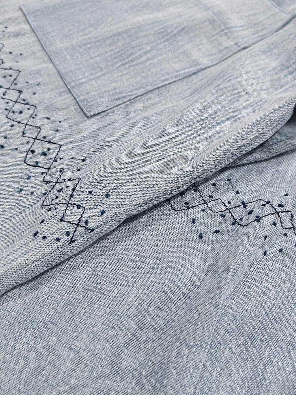 製品画像: ウォッシュ刺し子ストライプスタンドカラーデニムシャツ全体表示。東洋風デザインとモダンな刺し子刺繍が特徴のカジュアルシャツ。
詳細画像: ストライプ状の刺し子刺繍ディテール表示。民族風と幾何学模様が融合したデザインで、シャツのアクセントに。