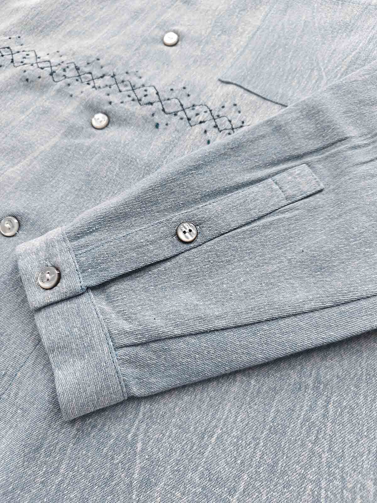 製品画像: ウォッシュ刺し子ストライプスタンドカラーデニムシャツ全体表示。東洋風デザインとモダンな刺し子刺繍が特徴のカジュアルシャツ。
詳細画像: ストライプ状の刺し子刺繍ディテール表示。民族風と幾何学模様が融合したデザインで、シャツのアクセントに。