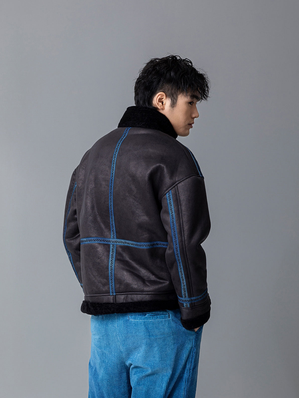 詳細画像: 草木模様のテープパッチワークディテール表示。ヴィンテージ感と高級感を兼ね備えたユニークな仕上がり。
モデル画像: モデル着用による厚手ムートンジャケットのシティスタイル。冬のカジュアルシーンに最適なアウター。