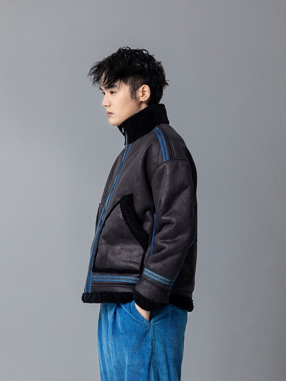 詳細画像: 草木模様のテープパッチワークディテール表示。ヴィンテージ感と高級感を兼ね備えたユニークな仕上がり。
モデル画像: モデル着用による厚手ムートンジャケットのシティスタイル。冬のカジュアルシーンに最適なアウター。