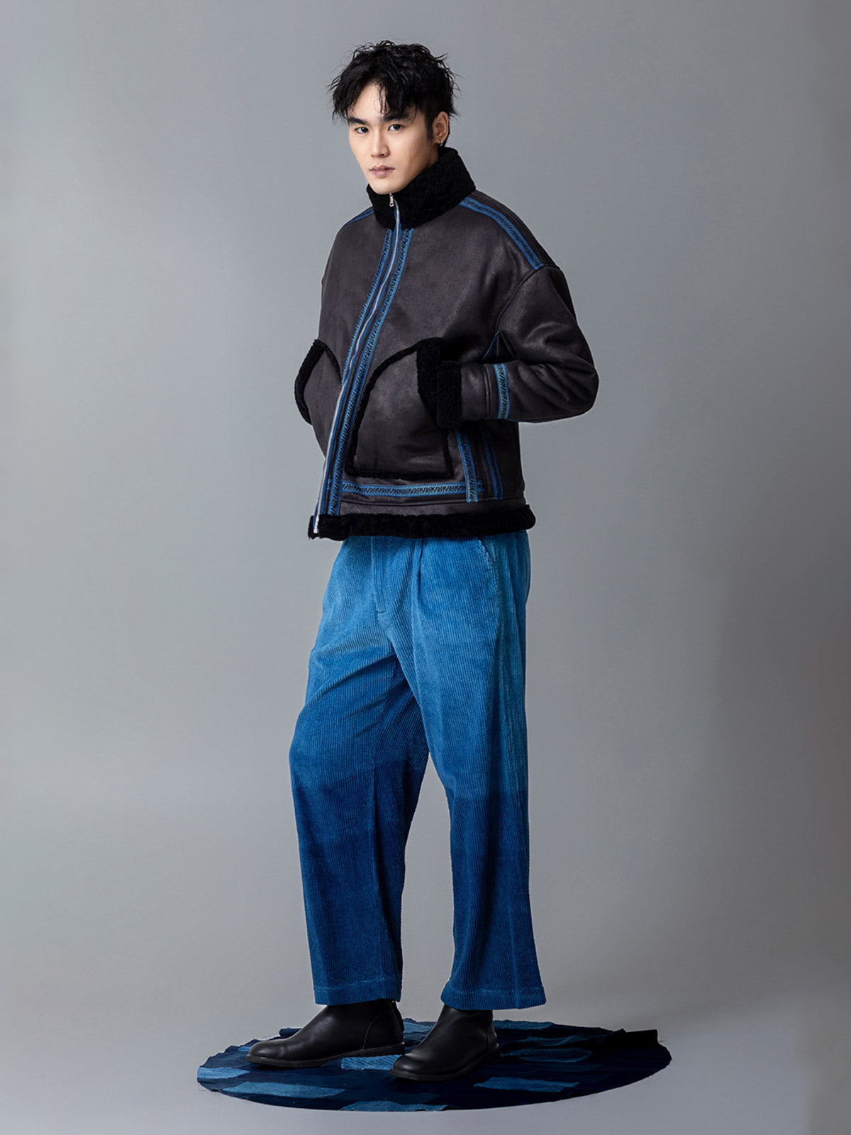 詳細画像: 草木模様のテープパッチワークディテール表示。ヴィンテージ感と高級感を兼ね備えたユニークな仕上がり。
モデル画像: モデル着用による厚手ムートンジャケットのシティスタイル。冬のカジュアルシーンに最適なアウター。