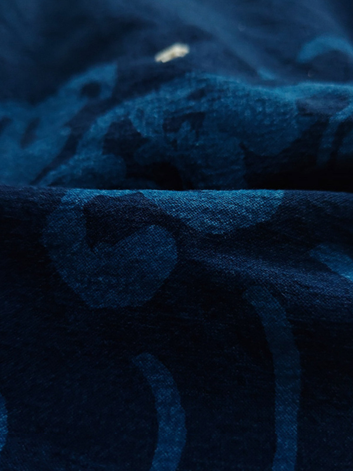 製品画像:抜染と段落ち抜染の和柄リネンはんてんの正面展示。複雑な模様と藍染が施された伝統的なデザインが魅力。
詳細画像:和柄の抜染と段落ち抜染のディテールをクローズアップ。刺し子刺繍と織り帯のディテールが、工芸的な価値を引き立てる。