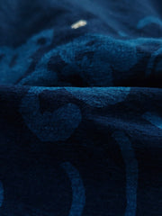 製品画像:抜染と段落ち抜染の和柄リネンはんてんの正面展示。複雑な模様と藍染が施された伝統的なデザインが魅力。
詳細画像:和柄の抜染と段落ち抜染のディテールをクローズアップ。刺し子刺繍と織り帯のディテールが、工芸的な価値を引き立てる。