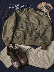 製品画像:ヴィンテージL-2フライトジャケットの正面展示。軽量ナイロン素材とリブディテールが特徴のクラシックなフライトジャケット。
詳細画像:酸素マスクホースクリップと真鍮製四合ボタンのディテールをクローズアップ。戦後の空軍スタイルを表現するディテール。