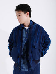 詳細画像: 藍染めストライプと多機能ポケットのディテール画像。ダイヤ柄キルティング加工の中綿が見える耐久性と保温性の高い仕上がり。
モデル画像: モデルが着用する藍染めとストライプパッチワークの民族風スタンドカラージャケット。スポーティーな袖口とゆったりとしたシルエットが映えるコーディネート。