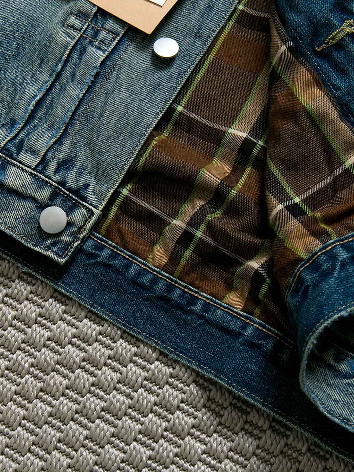 製品画像: ヴィンテージ風ダメージデニムジャケット全体表示。クラシックなチェック柄裏地とヘビーウェイトのコットン素材が特徴で、ワーク風シルエットが際立ちます。
詳細画像: ダメージ加工とチェック裏地のディテール表示。リアルなユーズド感とレイヤード効果がヴィンテージスタイルに深みを与えます。