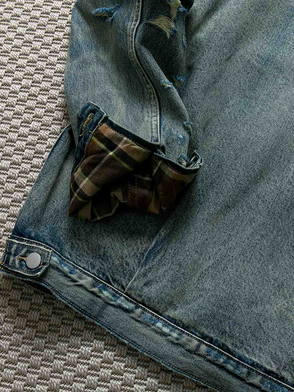 製品画像: ヴィンテージ風ダメージデニムジャケット全体表示。クラシックなチェック柄裏地とヘビーウェイトのコットン素材が特徴で、ワーク風シルエットが際立ちます。
詳細画像: ダメージ加工とチェック裏地のディテール表示。リアルなユーズド感とレイヤード効果がヴィンテージスタイルに深みを与えます。