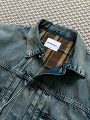 製品画像: ヴィンテージ風ダメージデニムジャケット全体表示。クラシックなチェック柄裏地とヘビーウェイトのコットン素材が特徴で、ワーク風シルエットが際立ちます。
詳細画像: ダメージ加工とチェック裏地のディテール表示。リアルなユーズド感とレイヤード効果がヴィンテージスタイルに深みを与えます。