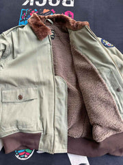 製品画像:
アメリカンヴィンテージ空軍フライトジャケット全体画像。クラシックなデザインが特徴的で、ウールライニングとコットン外層が融合し、保温性と耐久性を兼ね備えています。
詳細画像:
フライトジャケットのConmarジッパーとワッペンディテールのクローズアップ。ジャケットの高品質な縫製とヴィンテージミリタリーデザインが鮮明に映し出されています。