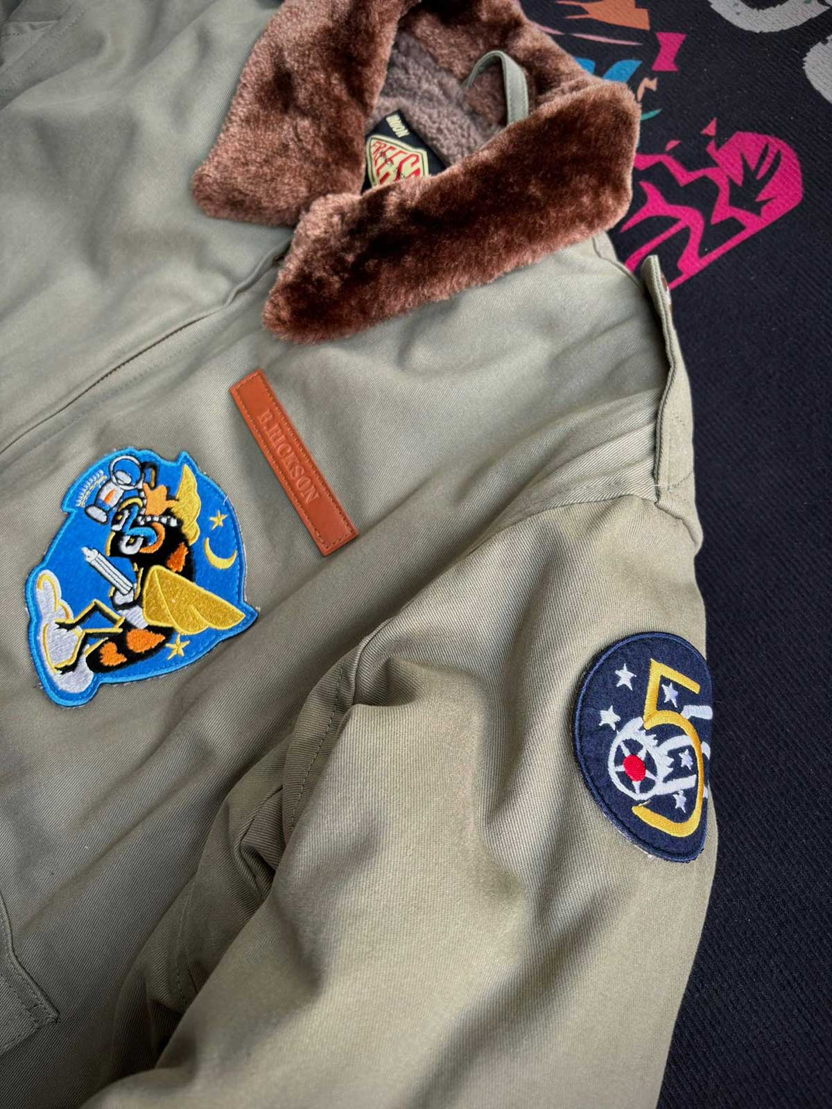 製品画像:
アメリカンヴィンテージ空軍フライトジャケット全体画像。クラシックなデザインが特徴的で、ウールライニングとコットン外層が融合し、保温性と耐久性を兼ね備えています。
詳細画像:
フライトジャケットのConmarジッパーとワッペンディテールのクローズアップ。ジャケットの高品質な縫製とヴィンテージミリタリーデザインが鮮明に映し出されています。