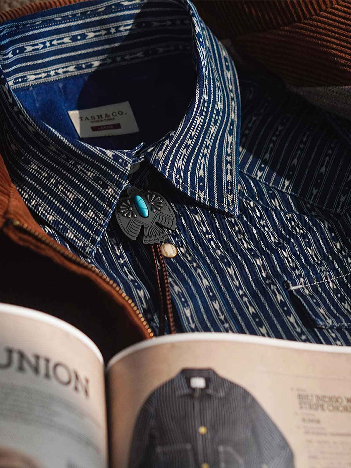 製品画像:Wabashプリントデニムシャツの全体展示。部分的に染料が取り除かれたユニークな白いプリントが施され、9オンスのコットンデニム素材が特徴的です。
詳細画像:Wabashプリントのディテールと、染料を取り除いた部分がはっきりとわかるテクスチャーが映し出されています。