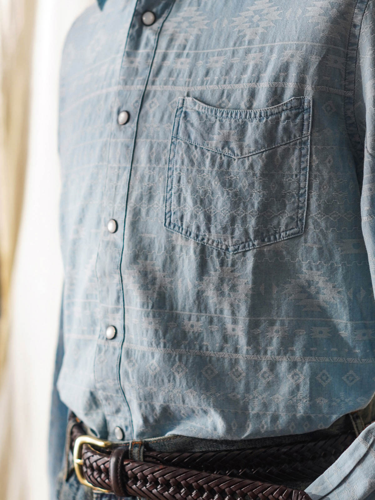 詳細画像(織り目とディテール):
ナバホ柄ジャガードデニムシャツの織り目とディテールを強調した画像。コットンとポリエステルの混合生地が耐摩耗性と通気性を提供する様子。
モデル画像(着用展示):
ナバホ柄ジャガードデニムシャツを着用したモデルの上身の展示。シャツのデザインと快適な着心地を強調。