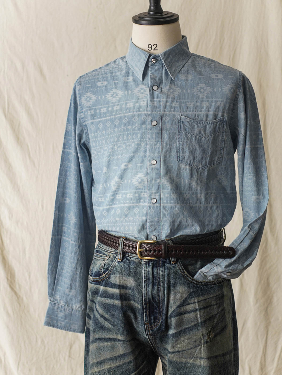 詳細画像(織り目とディテール):
ナバホ柄ジャガードデニムシャツの織り目とディテールを強調した画像。コットンとポリエステルの混合生地が耐摩耗性と通気性を提供する様子。
モデル画像(着用展示):
ナバホ柄ジャガードデニムシャツを着用したモデルの上身の展示。シャツのデザインと快適な着心地を強調。
