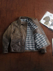 製品画像:ウォッシュ加工が施されたトップレザーのバイカージャケット全体展示。ヴィンテージ感とタフな印象が強調されています。
詳細画像:ジャケットのウォッシュ加工部分、チェック柄裏地、ショート丈デザインのディテールに焦点を当てたアップ画像。