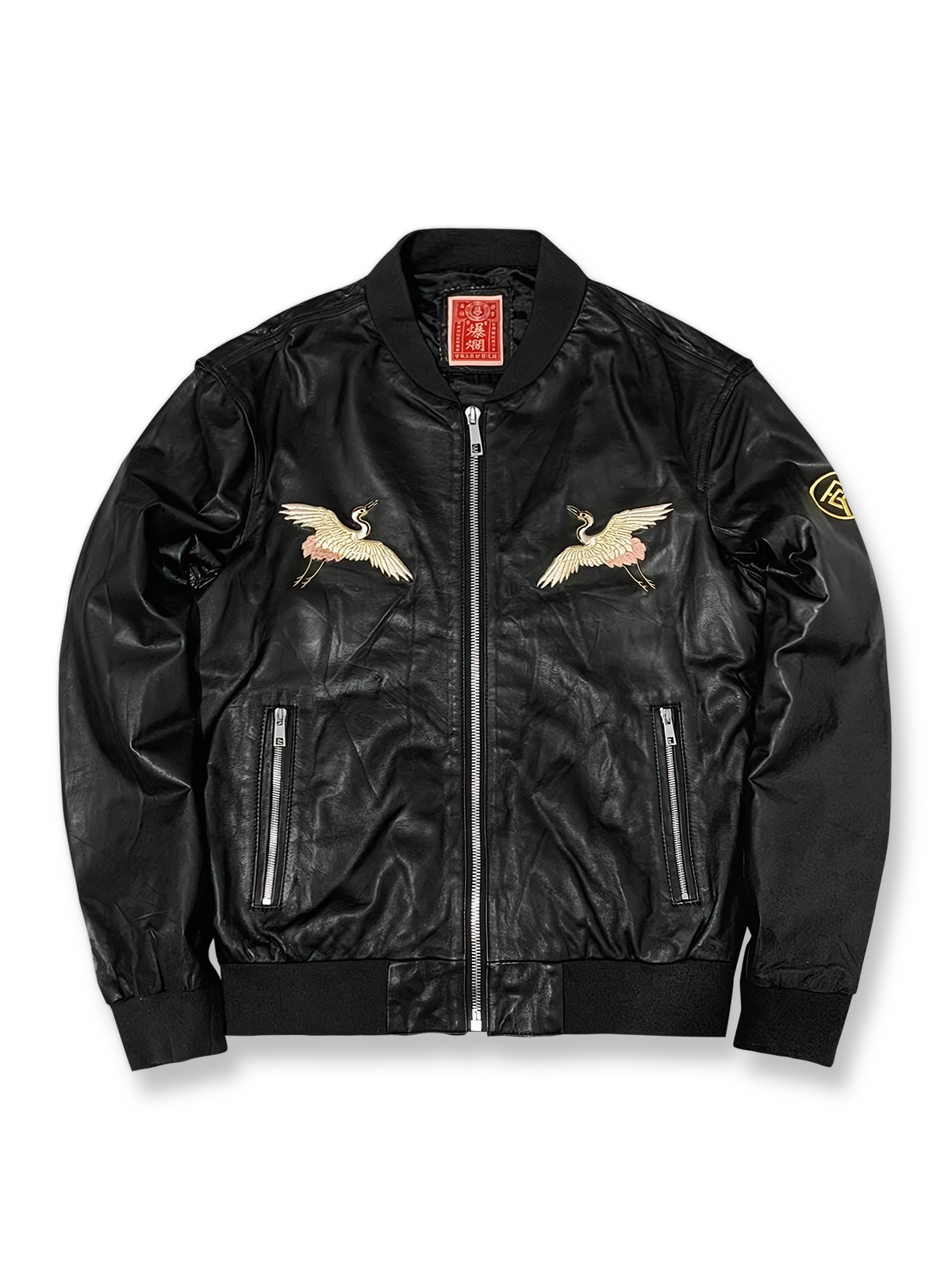 製品画像: 横須賀鶴図刺繍 羊革ジャケット全体画像、吉祥の象徴である「鶴図」刺繍と上質な輸入羊革のデザイン
詳細画像: 横須賀の伝統技法を用いた鶴、松、雲の刺繍ディテール、立体感ある精巧な工芸