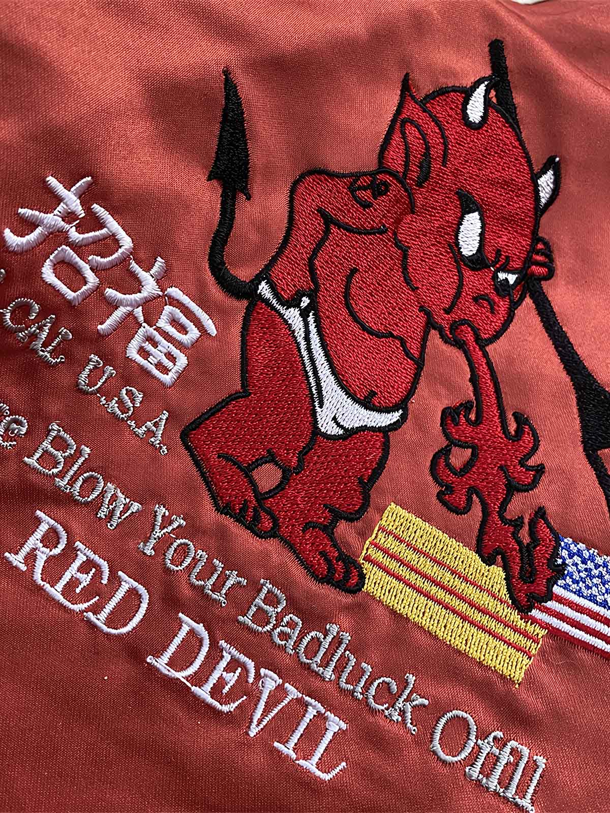 製品画像: リバーシブル 刺繍 横須賀 テッドマン 着物ギタリスト ジャケット全体画像、アメリカ文化と日本伝統を融合したデザイン
詳細画像: テッドマン(幸运の赤鬼)と着物ギタリストの刺繍ディテール、横須賀刺繍の芸術的な美しさと細部へのこだわり