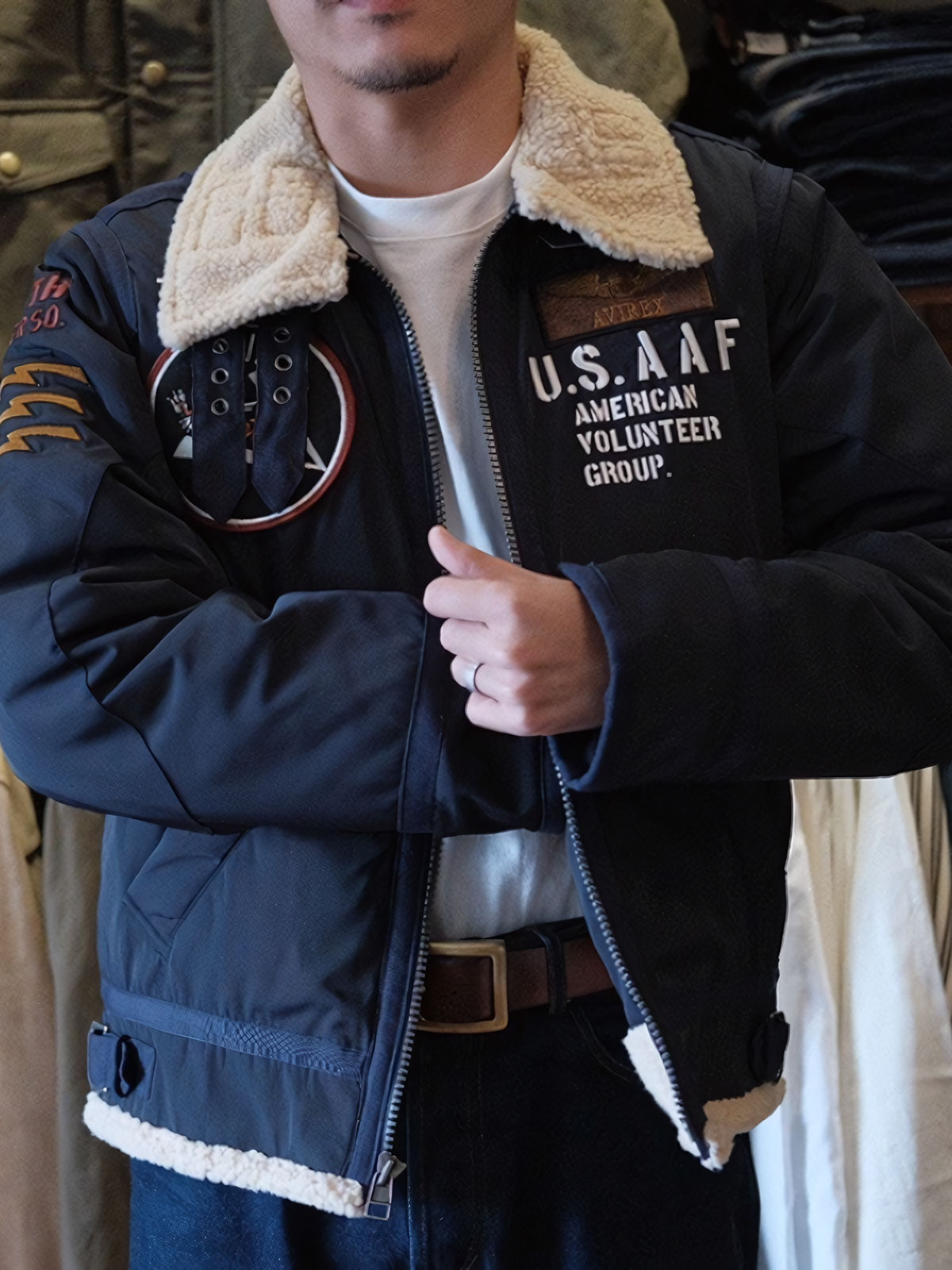 詳細画像:
胸元のワッペン刺繍と背面の「第74戦闘飛行中隊(74TH FIGHTER SQ.)」刺繍ディテール、アメリカ空軍の象徴的なデザイン。
モデル画像:
男性モデルがクラシックB3フライトジャケットを着用し、ミリタリーレトロスタイルのコーディネートを披露。