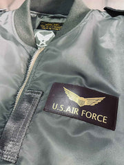 製品画像: L2-Bヴィンテージフライトジャケットの全体画像、ミリタリーグリーンとキャプテンランクの肩章が特徴のデザイン
詳細画像: 背面のポスター調デザインとキャプテンランク肩章のディテール、1940年代風のミリタリースタイル