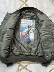 製品画像: ブラックバード飛行中隊 P40 フライングタイガース 刺繍入りフライトジャケットの全体画像、ミリタリーテイストとヴィンテージ感を融合したデザイン
詳細画像: ブラックバード飛行中隊とフライングタイガースの刺繍ディテール、リアルな「REMOVE BEFORE FLIGHT」タグ付き