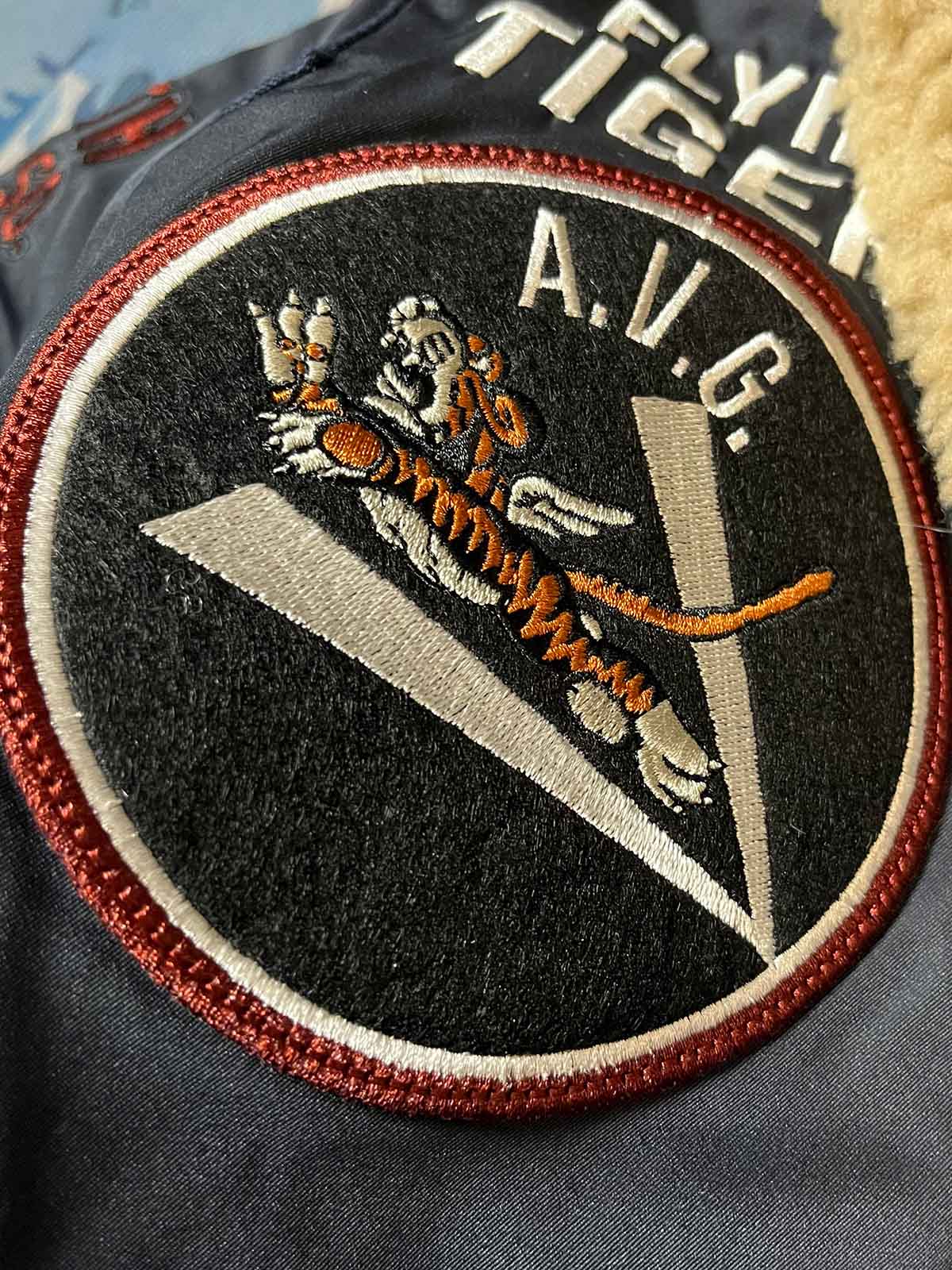 製品画像: 第74戦闘飛行中隊 B3 フライトジャケットの全体画像、シープスキン裏地とクラシックなミリタリースタイル
詳細画像: 背面の「74th FIGHTER SQ.」ロゴとアメリカ空軍マークの刺繍ディテール