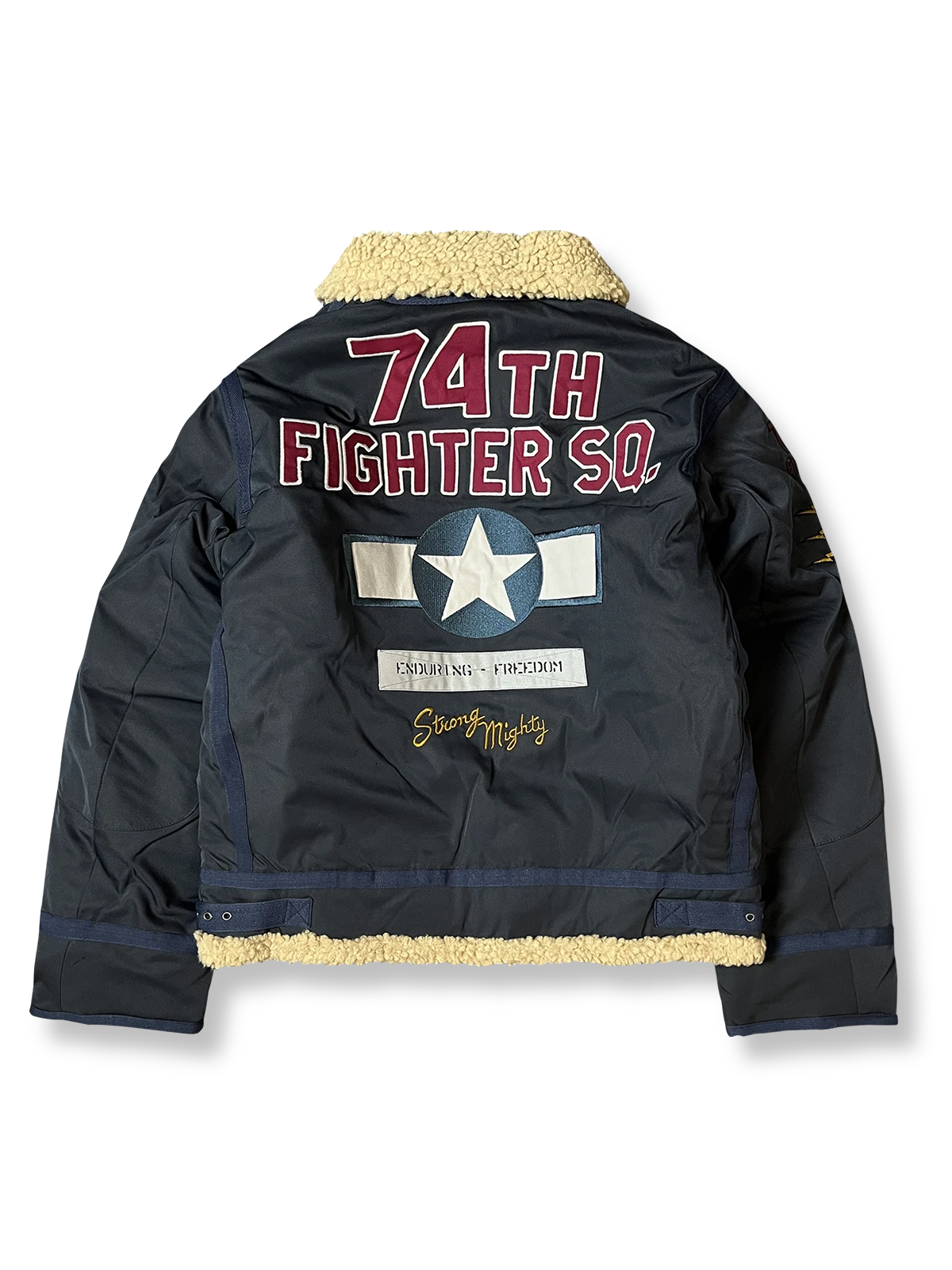 製品画像: 第74戦闘飛行中隊 B3 フライトジャケットの全体画像、シープスキン裏地とクラシックなミリタリースタイル
詳細画像: 背面の「74th FIGHTER SQ.」ロゴとアメリカ空軍マークの刺繍ディテール