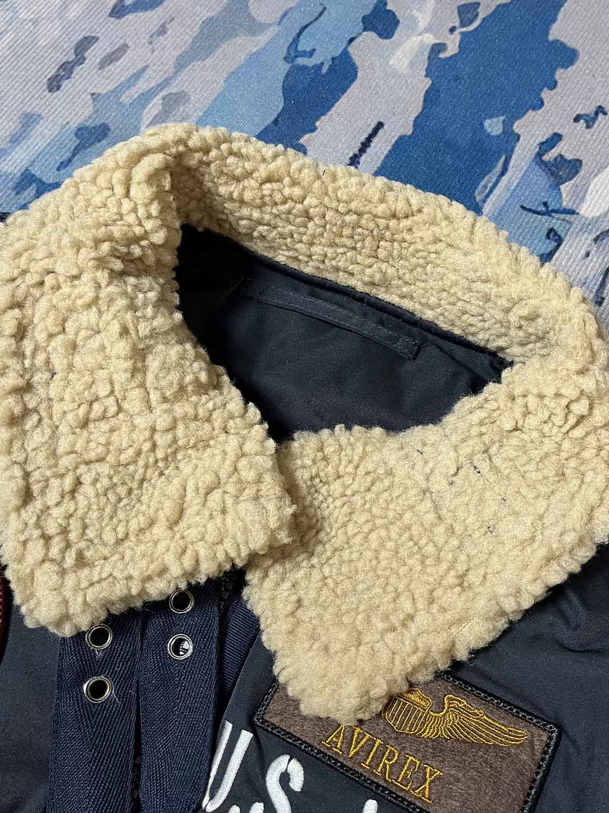 製品画像: 第74戦闘飛行中隊 B3 フライトジャケットの全体画像、シープスキン裏地とクラシックなミリタリースタイル
詳細画像: 背面の「74th FIGHTER SQ.」ロゴとアメリカ空軍マークの刺繍ディテール