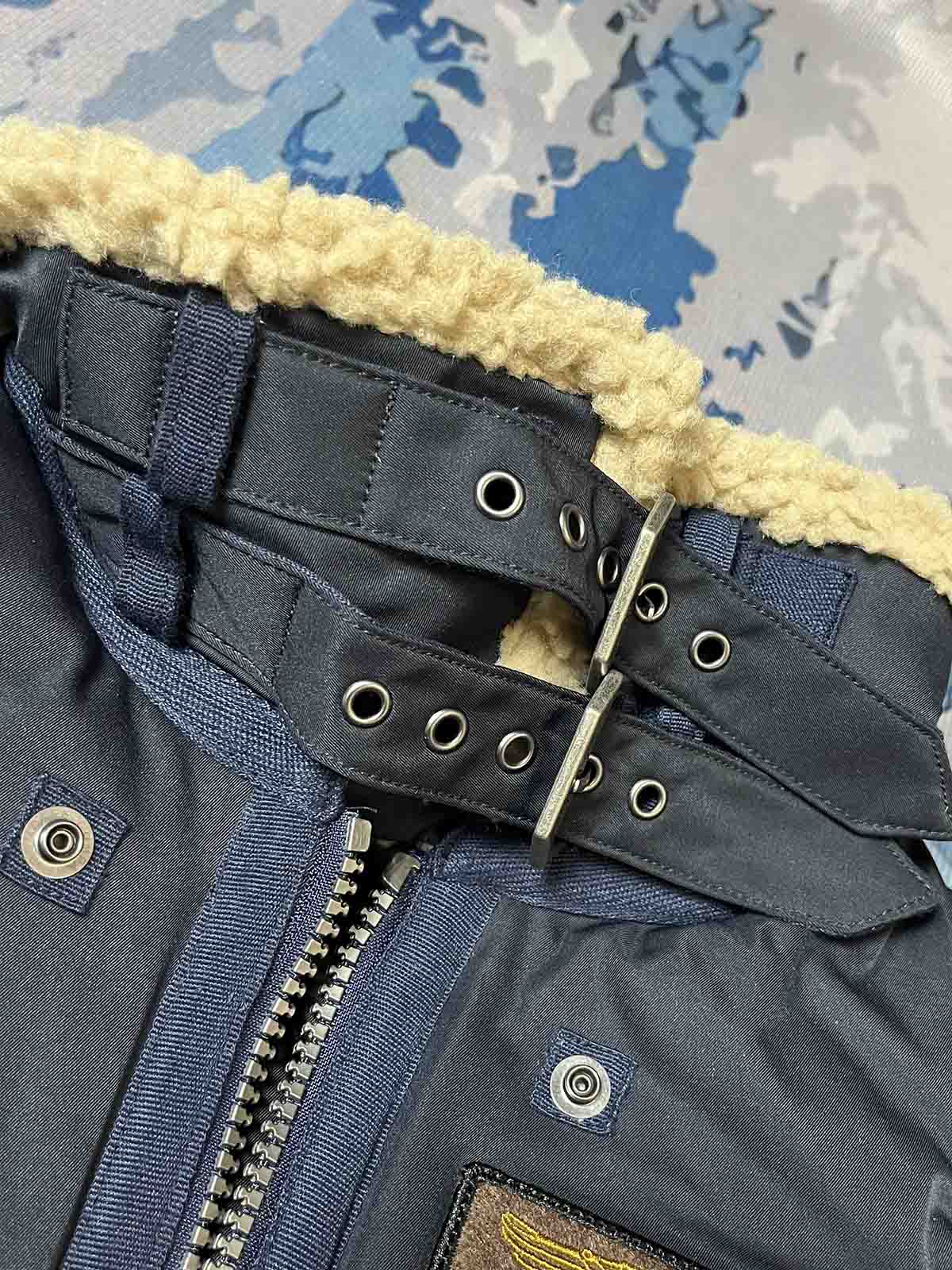 製品画像: 第74戦闘飛行中隊 B3 フライトジャケットの全体画像、シープスキン裏地とクラシックなミリタリースタイル
詳細画像: 背面の「74th FIGHTER SQ.」ロゴとアメリカ空軍マークの刺繍ディテール