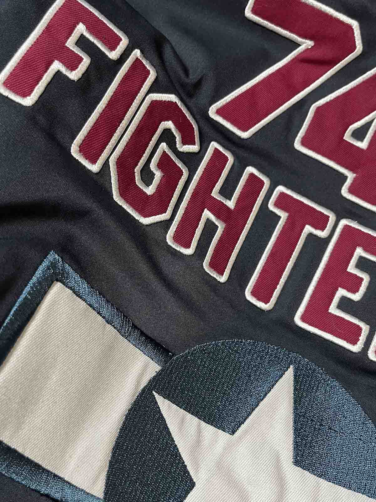 製品画像: 第74戦闘飛行中隊 B3 フライトジャケットの全体画像、シープスキン裏地とクラシックなミリタリースタイル
詳細画像: 背面の「74th FIGHTER SQ.」ロゴとアメリカ空軍マークの刺繍ディテール