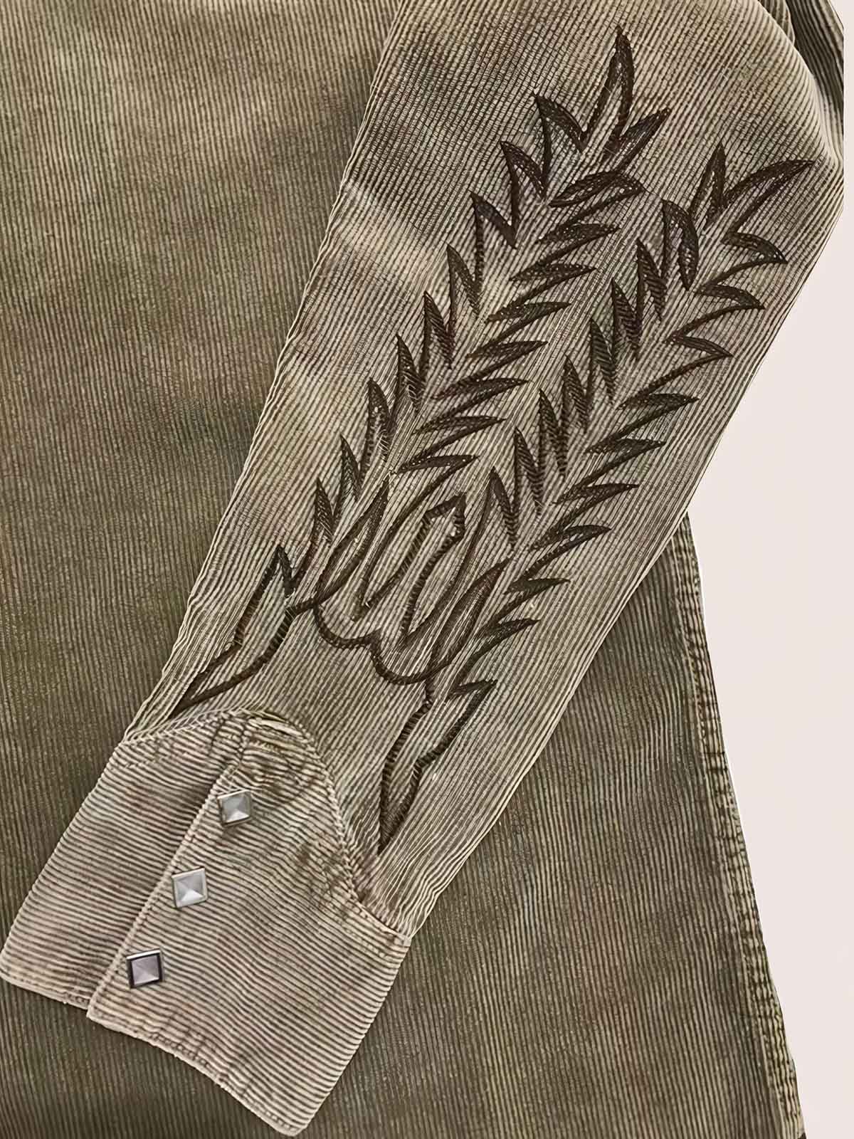 製品画像:アメカジヴィンテージコーデュロイ刺繍シャツの全体展示図、厚手のコットン素材で、ヴィンテージ風刺繍とシープレザー装飾が特徴的。
詳細画像:コーデュロイ刺繍シャツの刺繍模様とシープレザー装飾、ヴィンテージ風コンチョボタンと真鍮製ドットボタンのディテール。