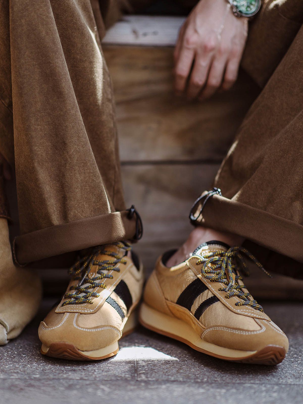 詳細画像: 側面のフルグレインホースレザー装飾とM字型トゥの型押しディテール、ヴィンテージスタイルの魅力を引き立てる細部をクローズアップで展示。
モデル画像: カジュアルからスポーツまで多様なシーンに対応するメンズレトロランニングシューズの着用例。80年代風のコーディネートで個性とファッション性を表現。