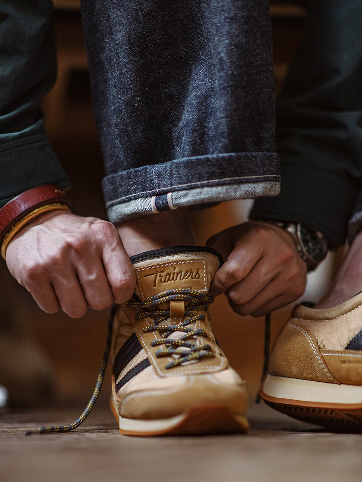 詳細画像: 側面のフルグレインホースレザー装飾とM字型トゥの型押しディテール、ヴィンテージスタイルの魅力を引き立てる細部をクローズアップで展示。
モデル画像: カジュアルからスポーツまで多様なシーンに対応するメンズレトロランニングシューズの着用例。80年代風のコーディネートで個性とファッション性を表現。