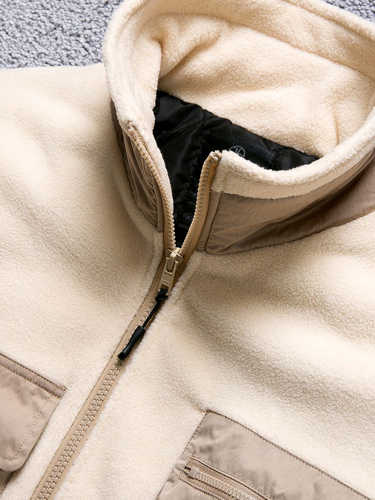 製品画像
カラーブロックフリースジャケットの正面画像。カラーブロックデザインが特徴的な、軽量で保温性に優れたフリース素材を使用した秋冬向けの多ポケットジャケット。
詳細画像
フリース素材を使用したカラーブロックデザインの多機能ポケットが特徴的なジャケットのディテール。収納力を高めるポケットと、立ち襟デザインが秋冬の寒さから守ります。