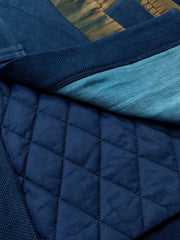 製品画像
植物藍染ピンチワークはんてんの全体展示。藍染めとピンチワークのデザインが際立ち、東洋的な風情が感じられるアイテム。冬のコーディネートにぴったりの暖かさとレトロスタイルが魅力です。
詳細画像
藍染ピンチワークとコットン入りのディテール画像。藍染め手織り布とピンチワークの細部が強調され、色合いや質感が鮮明に表現されています。商品の特徴を深く理解できる一枚です。