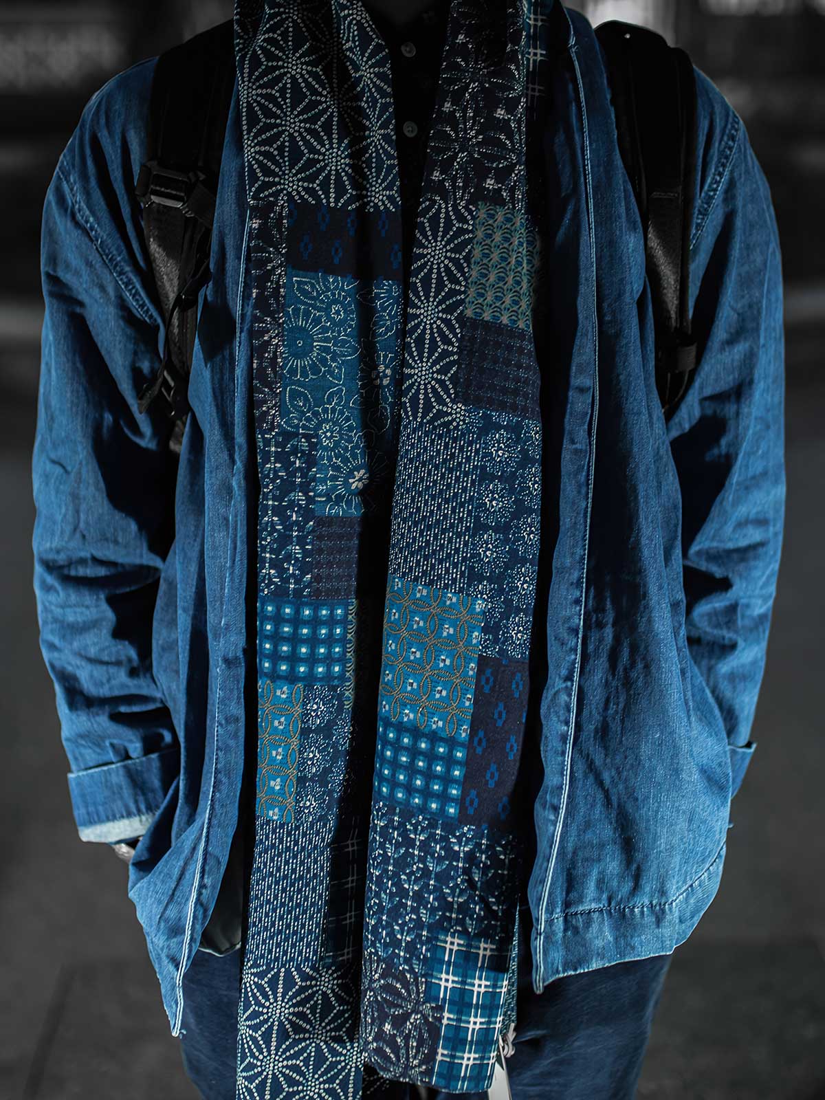 詳細画像
インディゴ藍染めパッチワークマフラーのプリント柄ディテール。繊細な藍染めとコットンリネン素材の質感が伝わるアップ画像。
モデル画像
モデルがインディゴ藍染めパッチワークマフラーを着用したコーディネート。レトロなデザインと現代的なスタイルの融合が、魅力的なアクセントに。