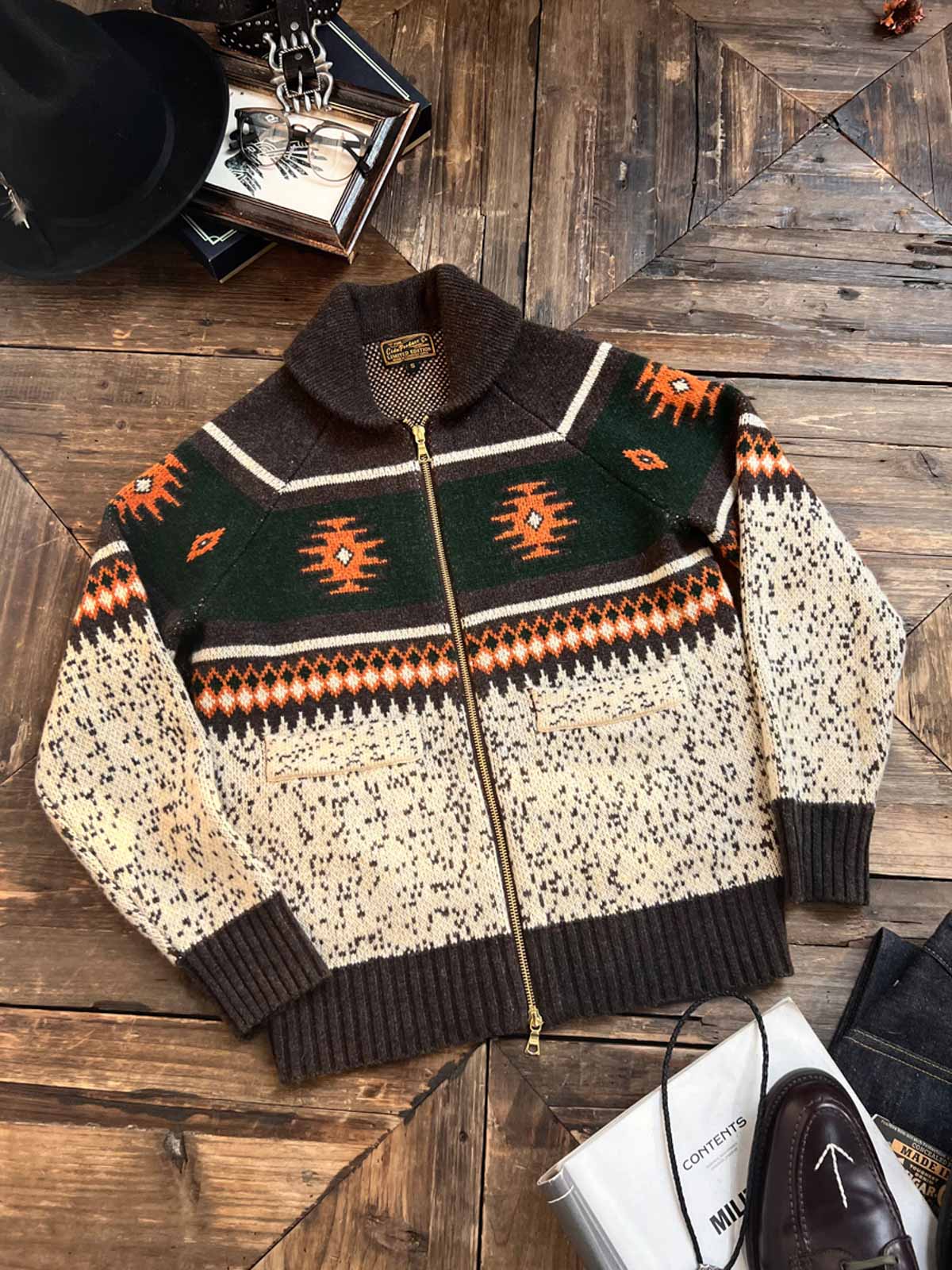 製品画像
ナバホ柄が特徴のオープンカラー(開襟)デザインのウール混紡カーディガン。民族幾何学模様が取り入れられたアメカジレトロスタイルで、秋冬のコーディネートに最適。厚手のウール混紡素材が保温性と快適さを提供する正面全体像。
詳細画像
ナバホ柄カーディガンのジッパーディテールとウール混紡素材の質感を特写。幾何学模様の編み込みデザインが民族風の魅力を強調し、耐久性と柔らかさを兼ね備えた生地の特徴を示すクローズアップ画像。