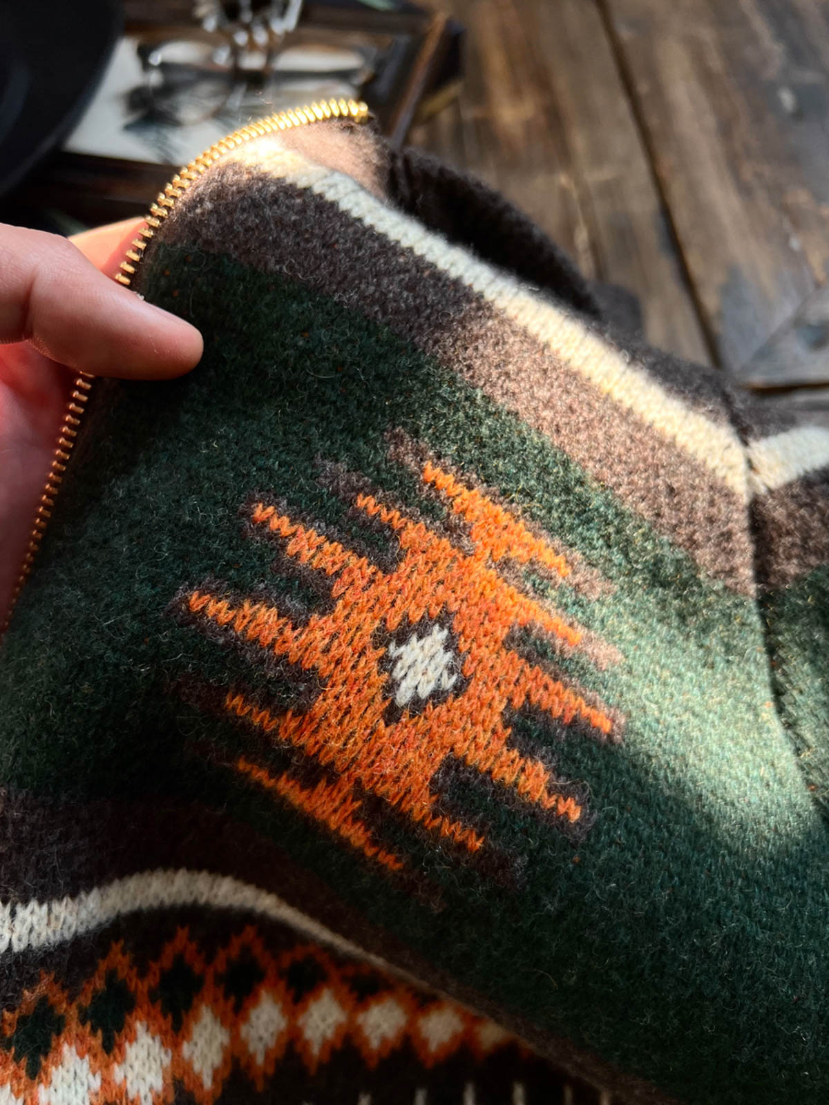 製品画像
ナバホ柄が特徴のオープンカラー(開襟)デザインのウール混紡カーディガン。民族幾何学模様が取り入れられたアメカジレトロスタイルで、秋冬のコーディネートに最適。厚手のウール混紡素材が保温性と快適さを提供する正面全体像。
詳細画像
ナバホ柄カーディガンのジッパーディテールとウール混紡素材の質感を特写。幾何学模様の編み込みデザインが民族風の魅力を強調し、耐久性と柔らかさを兼ね備えた生地の特徴を示すクローズアップ画像。