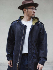 詳細画像: YKK製スナップボタンと特注シルバーカラージッパー、ブルー樹脂ボタンのディテールをクローズアップした画像。ヴィンテージ感を引き立てる丁寧なディテールが際立つ。
モデル画像: モデルがデニムバージョンのM51フィッシュテールコートを着用し、カーゴパンツとスニーカーを合わせたヴィンテージミリタリースタイルのコーディネート画像。軽やかさと保温性を両立した冬のデイリースタイルを提案。