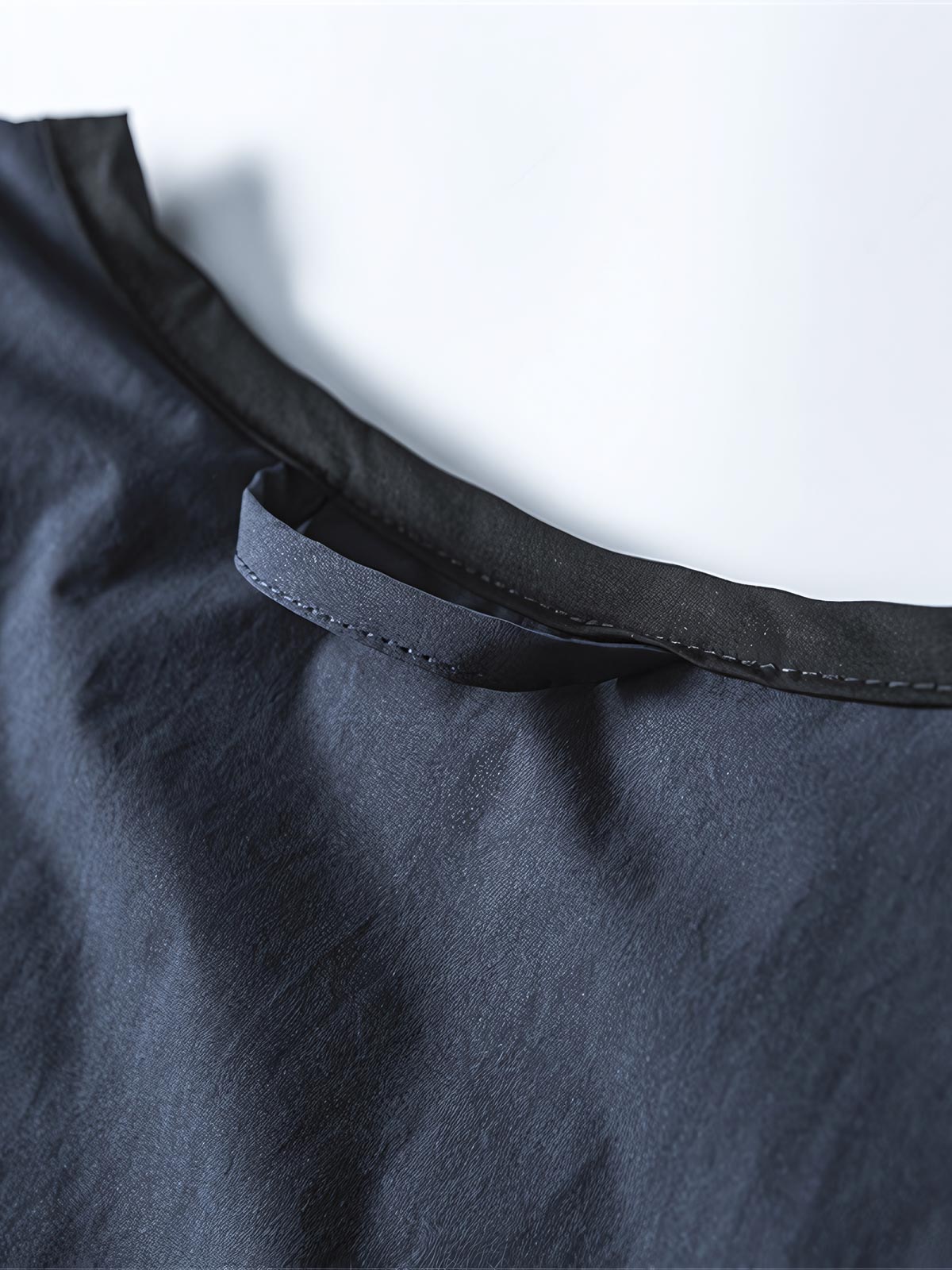 製品画像: リバーシブル撥水・撥油・防汚軽量ダウンジャケットの全体イメージ画像。ホワイトダックダウン90%を使用した中綿と、特別なテフロンコーティングを施した外層が特徴的。グレーベージュとネイビーの両面デザインで、アウトドアから日常コーデまで幅広く活用可能。
詳細画像: 撥水・撥油・防汚加工が施された外層と、軽量ホワイトダックダウン中綿をクローズアップしたディテール画像。耐久性と保温性を兼ね備えた素材が際立つ。