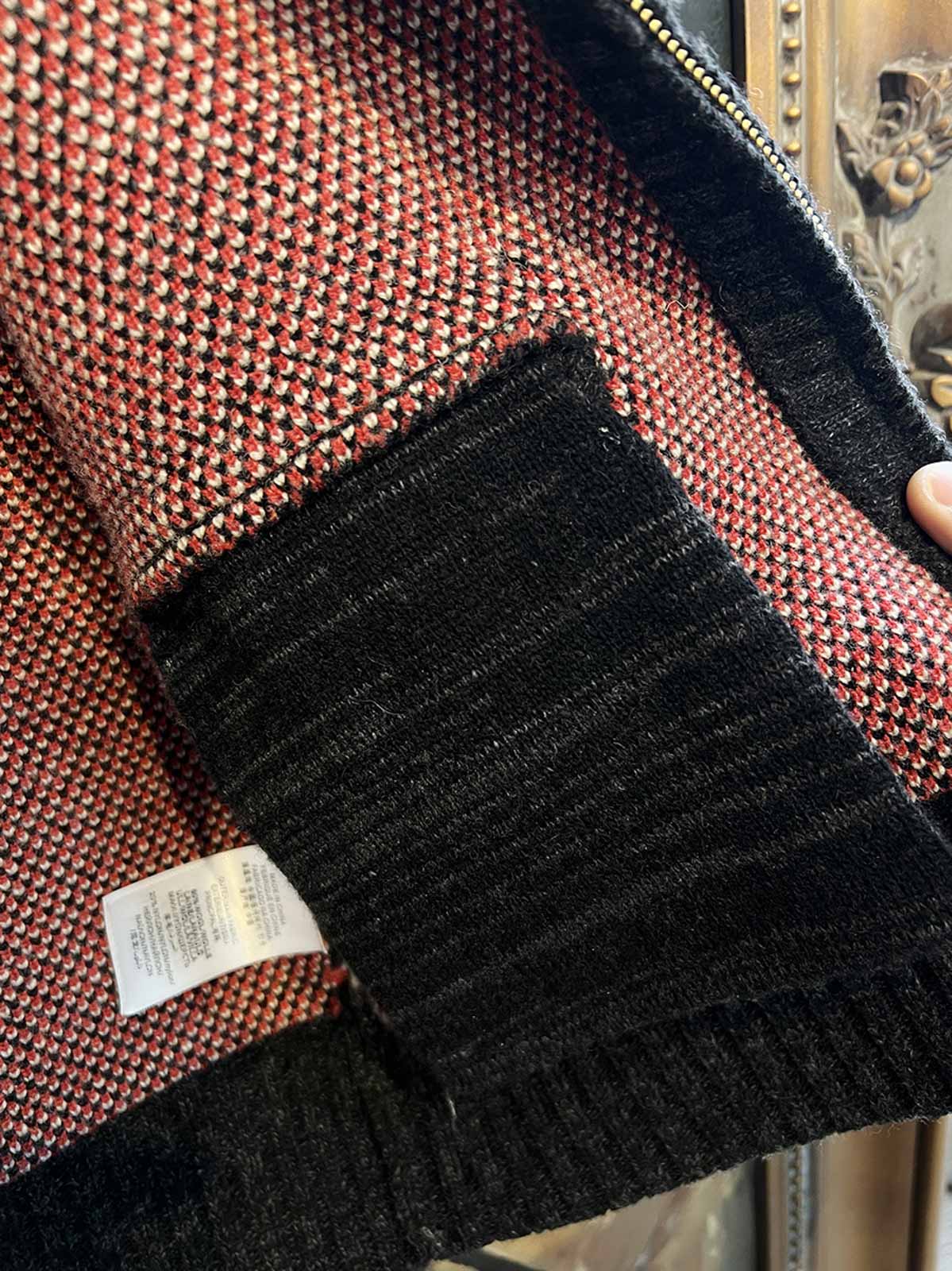 製品画像: ヴィンテージバイカージャカードウールカーディガン全体イメージ画像。バイクモチーフのジャカード織りと赤・黒・白のクラシックな配色が特徴で、自由とヴィンテージ感を象徴するデザイン。秋冬の重ね着スタイルに最適。
詳細画像: ジャカード織りで描かれたバイクモチーフと、クラシックなダブルジップディテールをクローズアップした画像。暖かいウール素材と細部へのこだわりが際立つ。